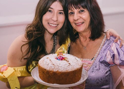 Two educators in costume holding a cake