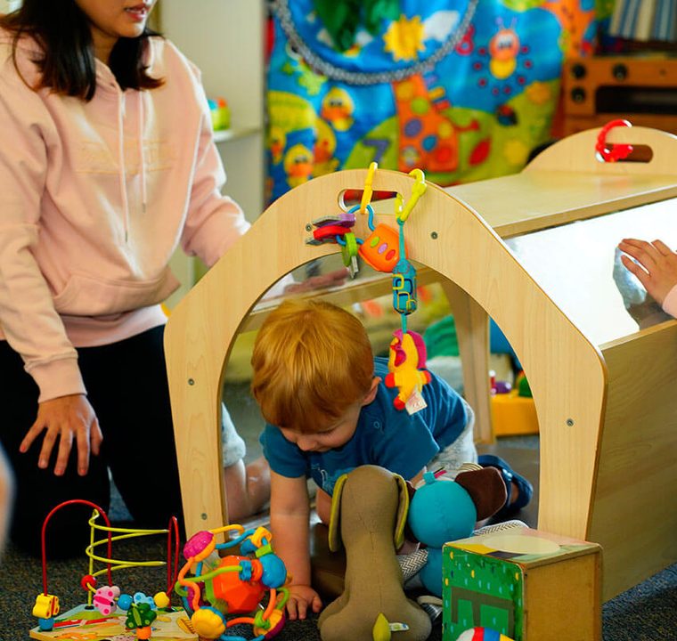 Educator playing with a baby at an activity centre