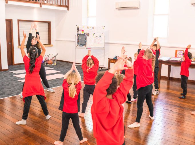 Children dancing in the hall with its wooden floor