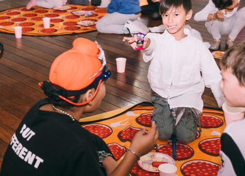 Children sitting on pizza rugs during an activity